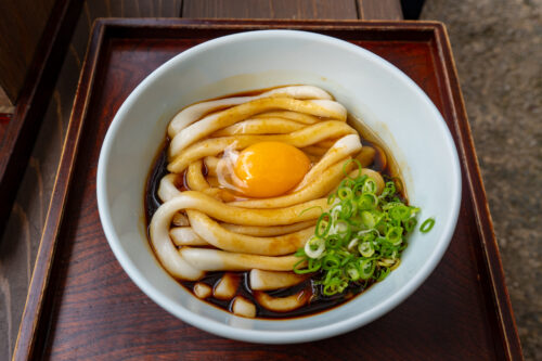 伊勢うどん:濃いタレに絡んだ太い麺と月見の卵黄