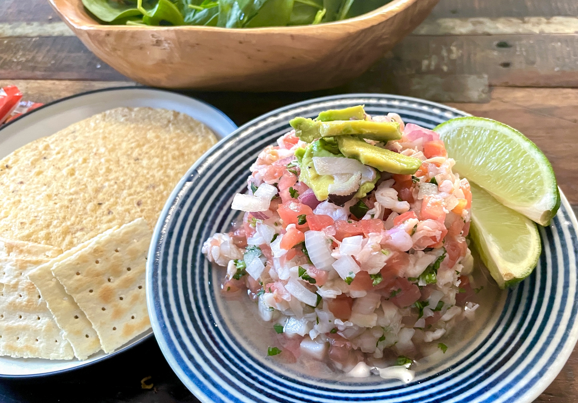 みじん切りのトマトやたまねぎ、アボカドのタコベジタブルに添えられた新鮮なスマイルカットのライム